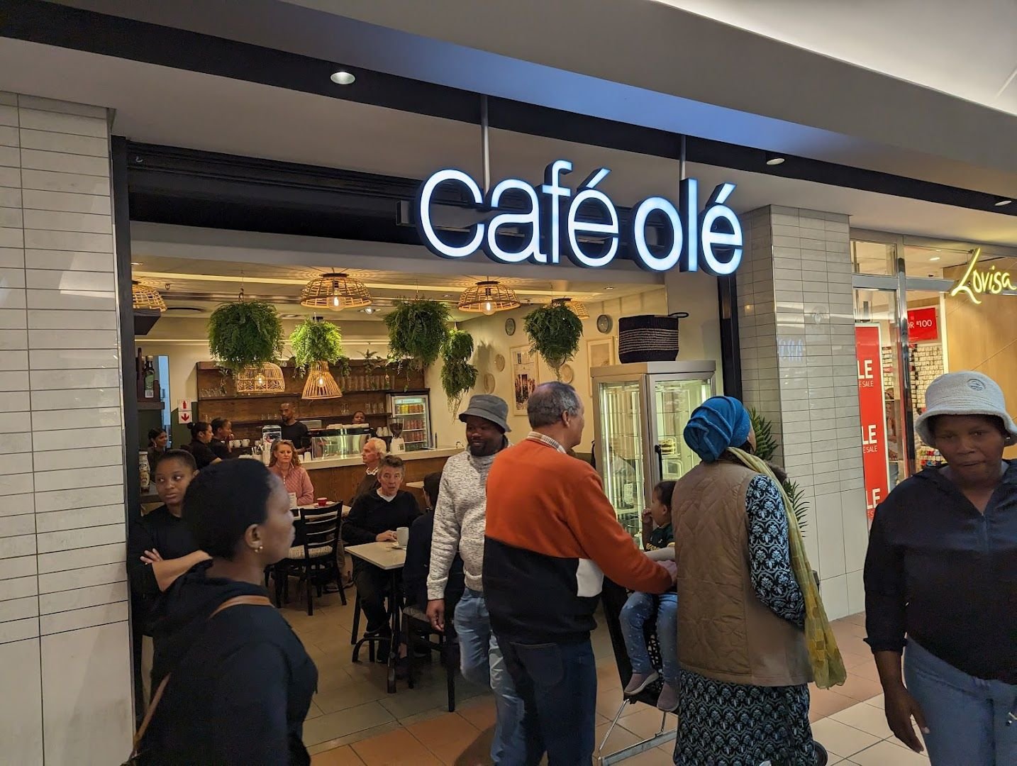 café olé storefront — illuminated wordmark above the entrance, Somerset Mall